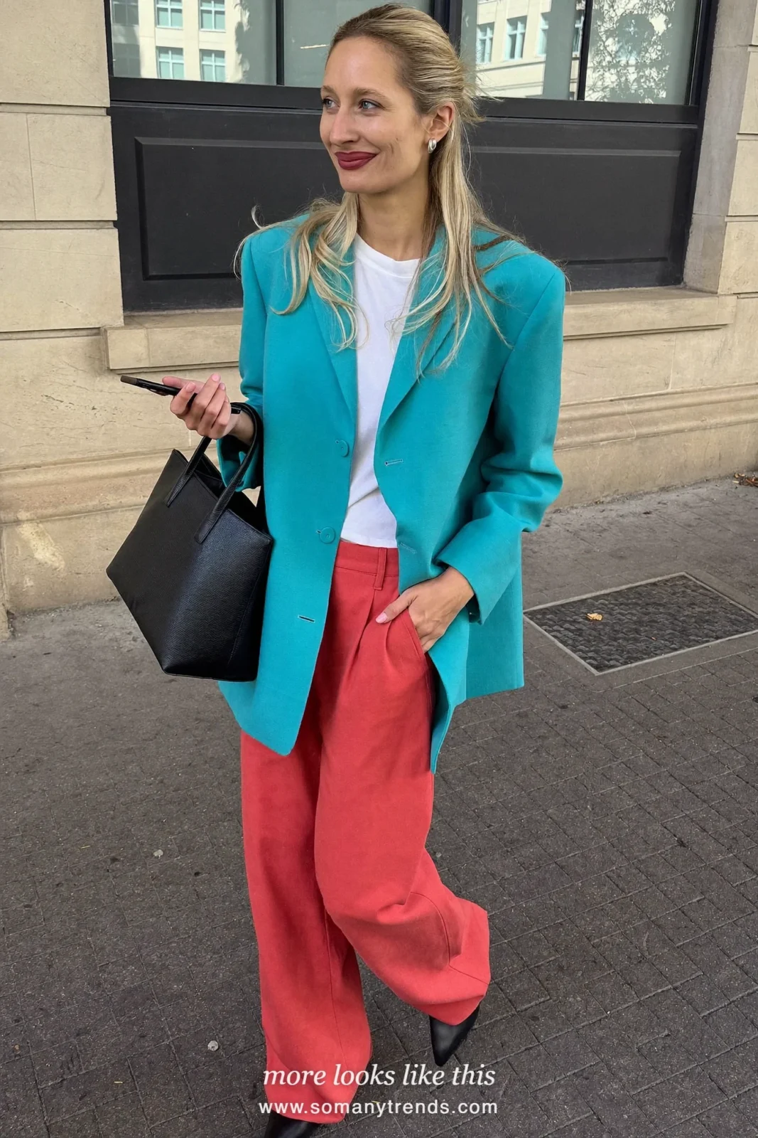 Woman in an oversized aqua blazer, white tee, coral red pants and black flats, outfit 16