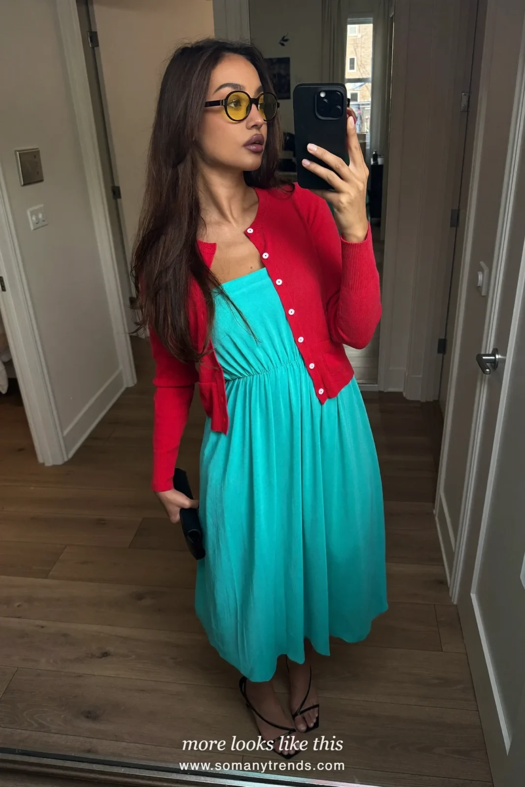 Woman in an aqua midi dress, coral red cardigan, black sandals and a small clutch, outfit 18