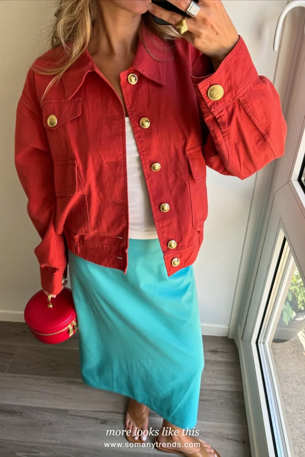 Woman in a coral red bomber jacket, white tank, aqua midi skirt and flat sandals, outfit 3