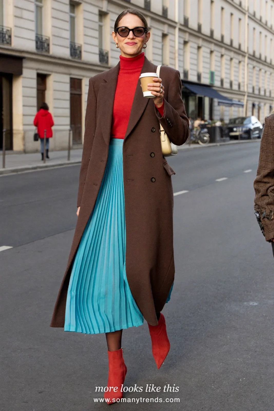 Woman in a long chocolate brown coat, coral red turtleneck, aqua pleated midi skirt and red ankle boots, outfit 9