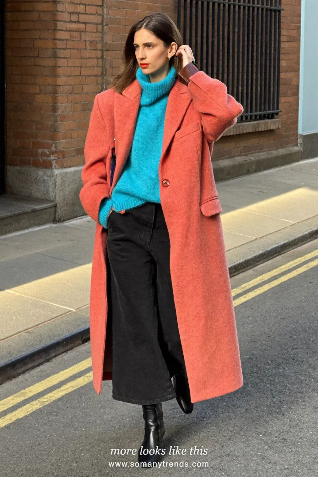 Woman in a long coral red coat, aqua knit, black wide pants and black boots, outfit 21
