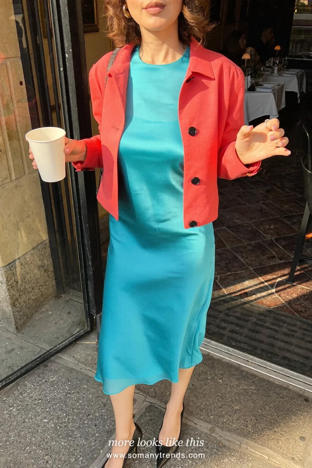 Woman in an aqua slip dress, coral red jacket, black heels and a clutch, outfit 23