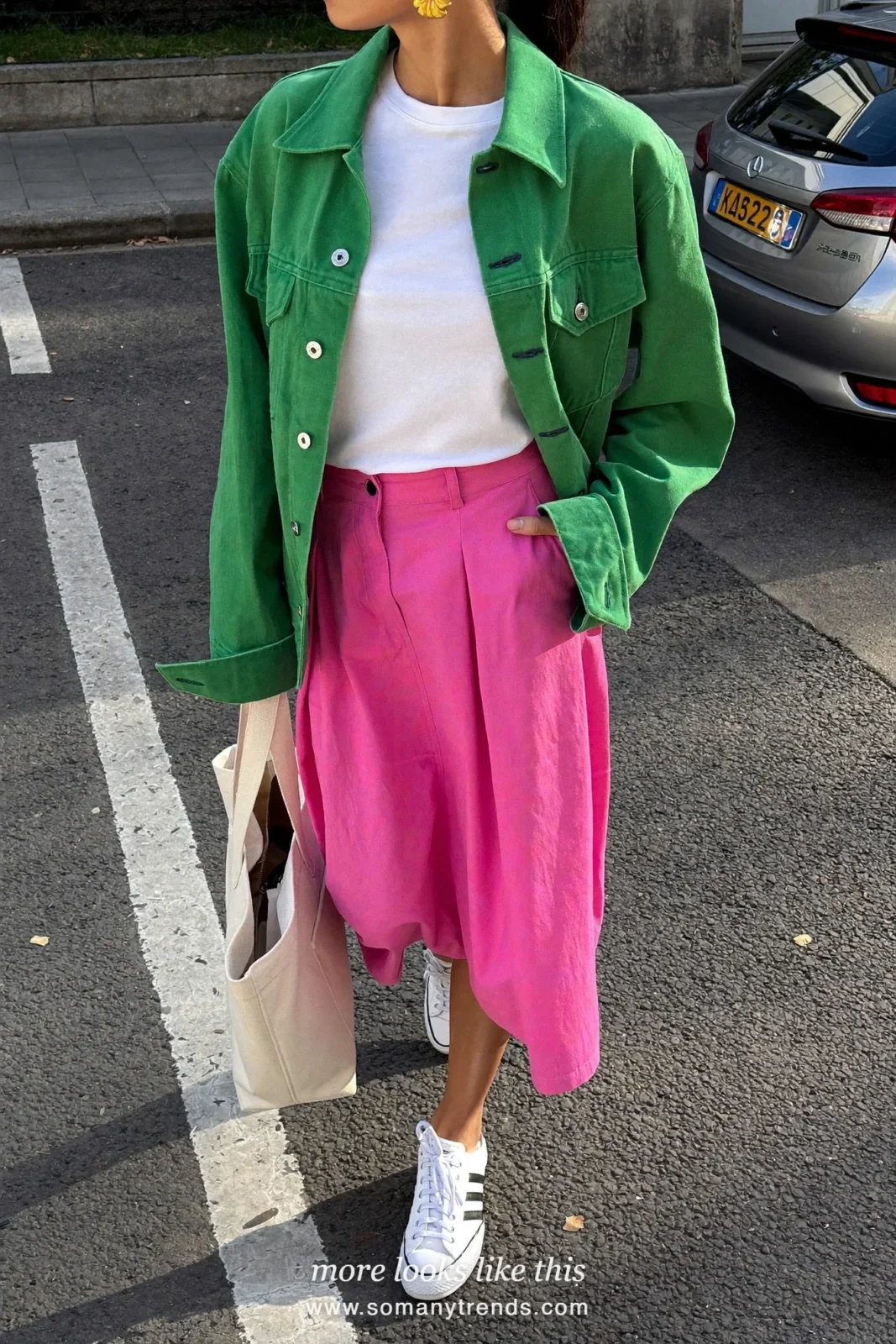 Woman in a moss green denim jacket, white tee, bright pink poplin midi skirt and white sneakers, outfit 20